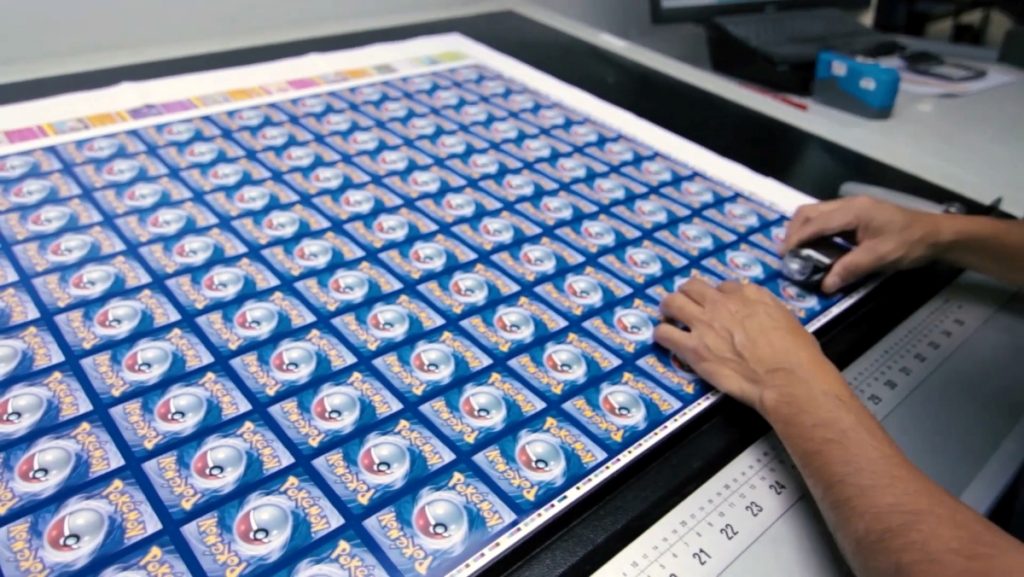 An uncut sheet of Pokémon cards being inspected within the factory.